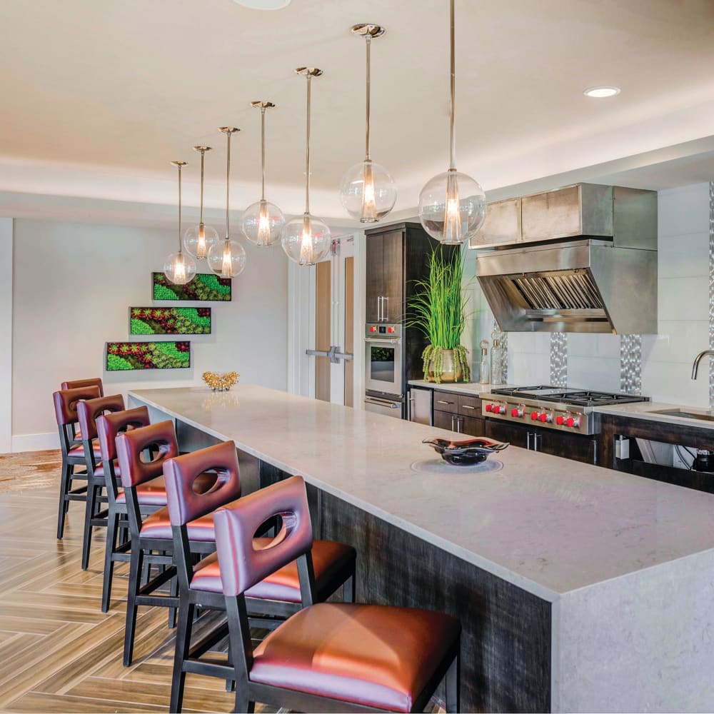 Kitchen area with a bar lined with chairs at Anthology of Tanglewood in Houston, Texas
