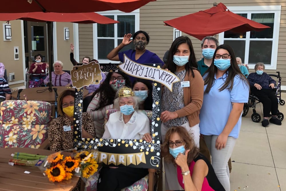 Resident and masked caretakers celebrating outside at Anthology Senior Living in Denver, Colorado