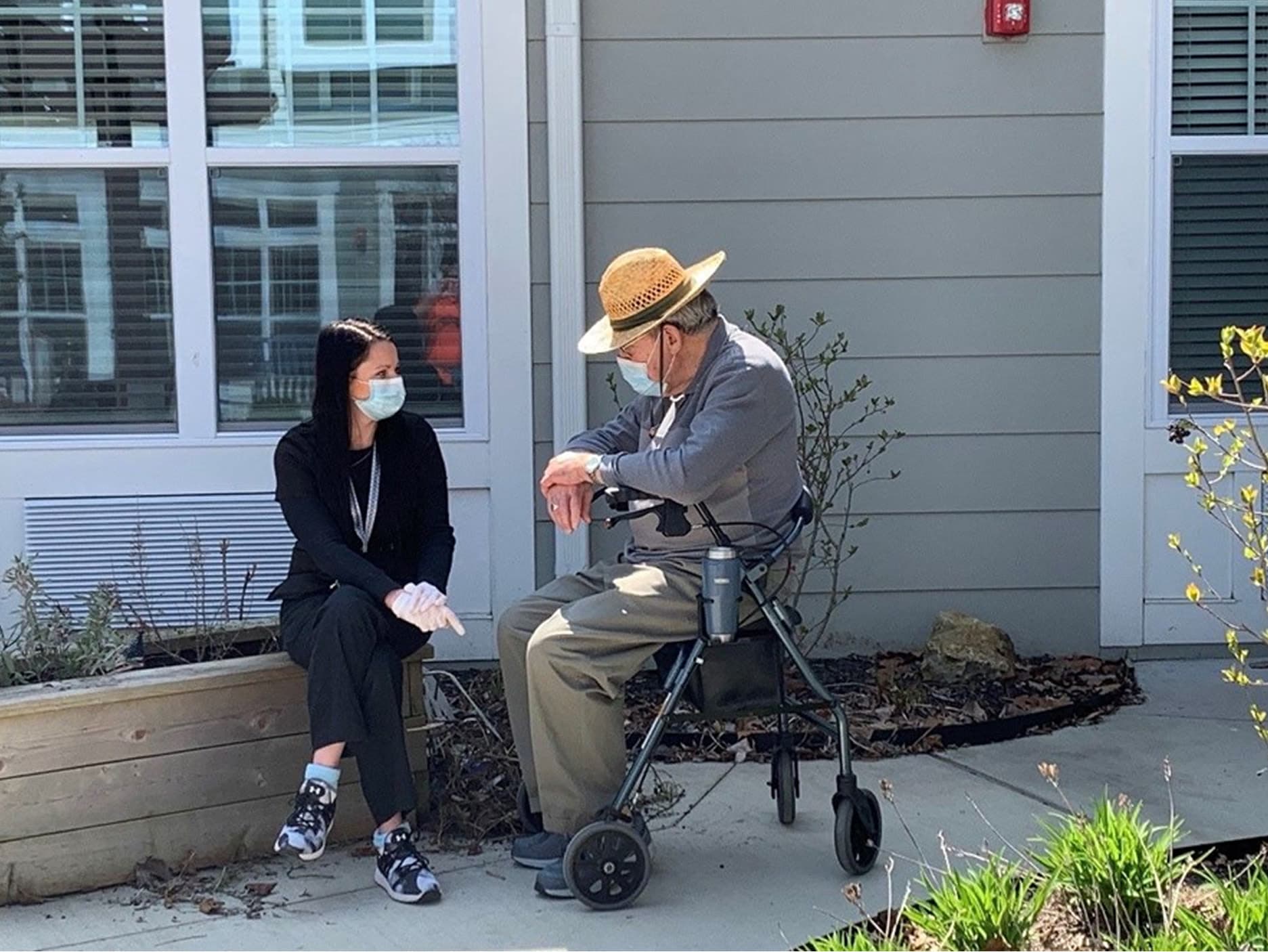 Resident sitting outside with a caretaker at a Anthology Senior Living location