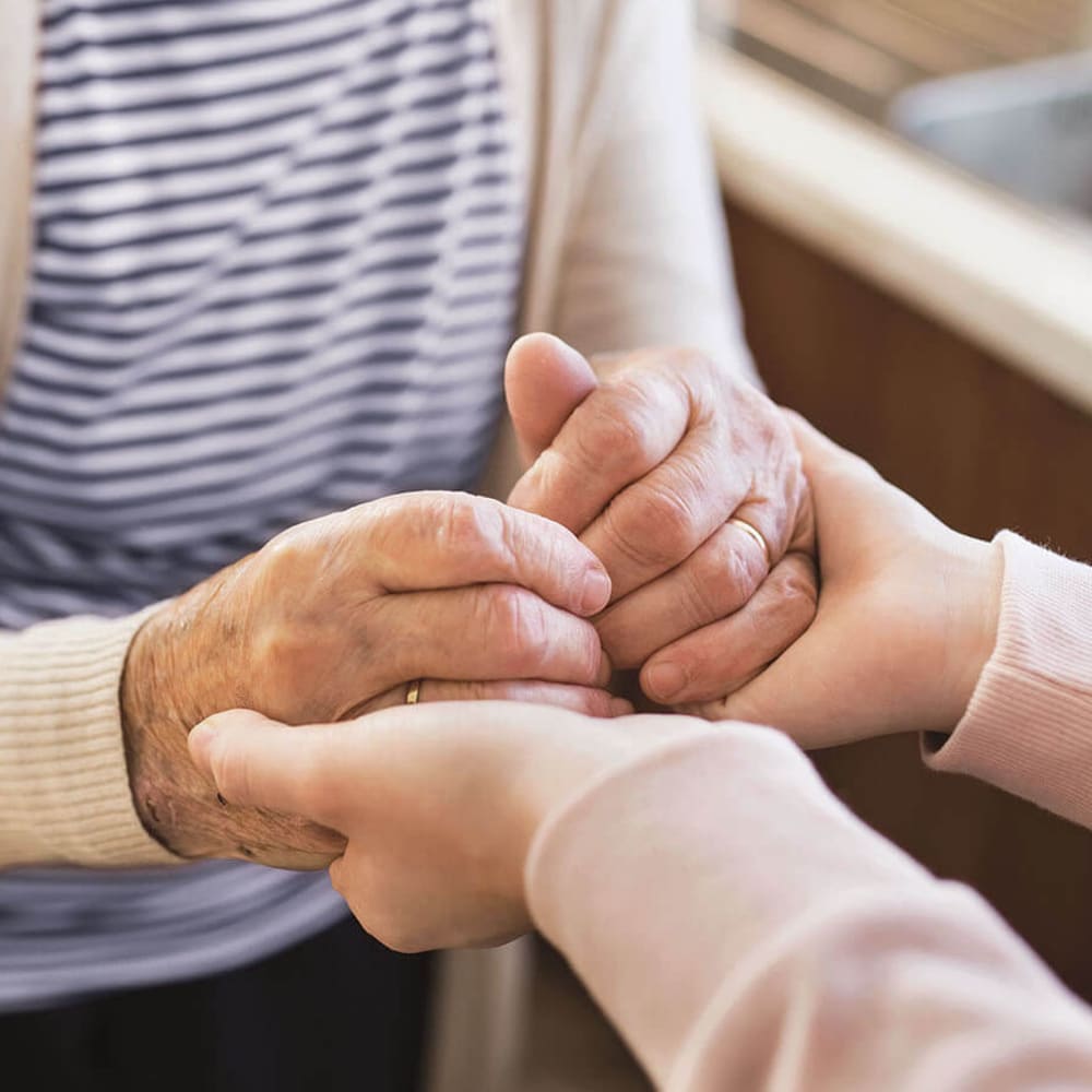 Caregiver holding resident's hands at Anthology of Highland Park in Dallas, Texas