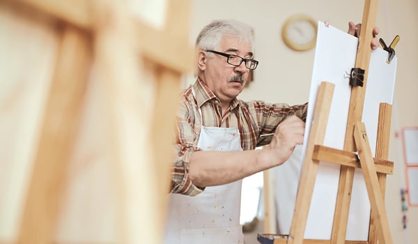 Elderly man working on a painting at Anthology Senior Living in Denver, Colorado